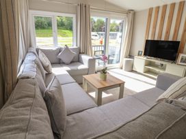 A living room with a sofa and television at The Oaks 2 Bedrooms in Delamere
