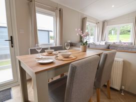 A dining room with a table set for a meal at The Oaks 2 Bedrooms in Delamere