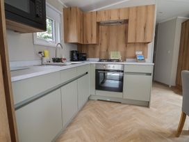 A kitchen with cabinets and appliances at The Oaks 2 Bedrooms Delamere