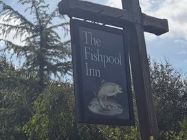 A sign for The Fishpool Inn with a fish graphic
