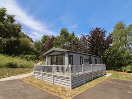 A house with decking and windows at The Oaks 2 Bedrooms in Delamere