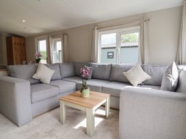A living room with a sofa and coffee table at The Oaks 2 Bedrooms Delamere