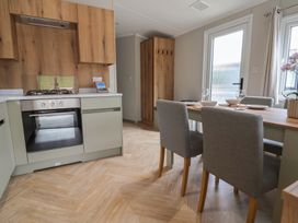 A kitchen with an oven and dining area at The Oaks 2 Bedrooms Delamere