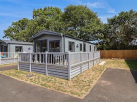 A mobile home with a deck and fence at The Oaks 2 Bedrooms Delamere