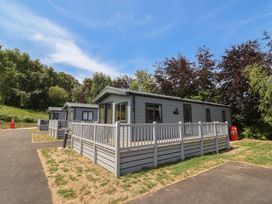 Cabins with porches and walkways at The Oaks 2 Bedrooms in Delamere