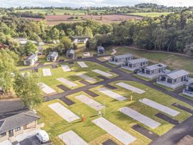 An outdoor area with holiday homes and grassy spaces at The Oaks 3 Bedrooms in Delamere