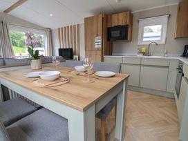 A kitchen with a dining table set and appliances at The Oaks 3 Bedrooms Delamere
