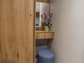 A dressing room with a mirror and flower pot at The Oaks 3 Bedrooms in Delamere