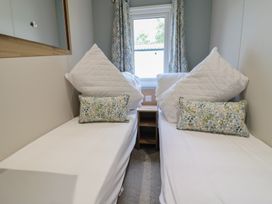 A bedroom with two beds and decorative cushions at The Oaks 3 Bedrooms Delamere