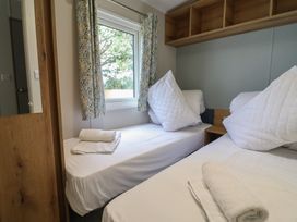 A bedroom with two beds and a window at The Oaks 3 Bedrooms in Delamere