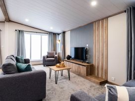 A living room with a television and seating area at No 9 Blakemere Lodge Escape Northwich