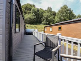 A deck with a chair and a hot tub at Cedar Lodge 2 Bedrooms with hot tub, Delamere