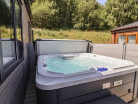 A hot tub on a deck at Cedar Lodge 2 Bedrooms with hot tub in Delamere