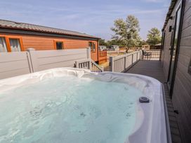 A hot tub on a deck area at Cedar Lodge 2 Bedrooms with hot tub in Delamere