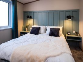 A bedroom with a bed and bedside tables at No 7 Delamere Lodge Retreat in Northwich
