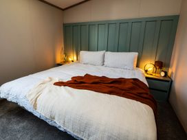A bedroom with a bed and bedside table at No 7 Delamere Lodge Retreat Northwich