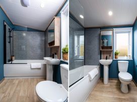 A bathroom with bath tub, shower, toilet, and sink at No 7 Delamere Lodge Retreat, Northwich