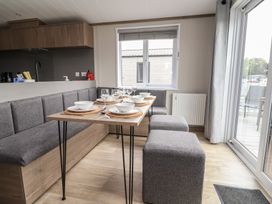 A dining area with a table and seating at Cedar Lodge 2 Bedrooms Delamere