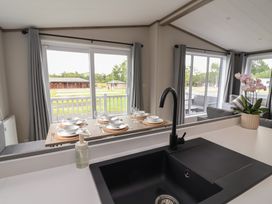 A kitchen with a dining table set for four at Cedar Lodge 2 Bedrooms Delamere