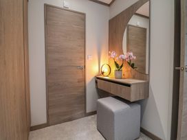 An entrance area with a mirror and plant at Cedar Lodge 2 Bedrooms Delamere