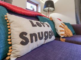 A living room with a couch and decorative pillows at The Pantiles in Banham