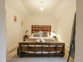 A bedroom with a wooden bed and bedside tables at The Pantiles in Banham