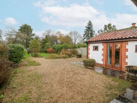 A garden with a gravel path and trees at The Pantiles in Banham