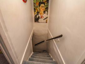 A staircase with a handrail and artwork on the wall at Frida's Cottage in Whitby