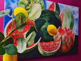 A branch with leaves and a lemon near a painting of fruits at Frida's Cottage in Whitby