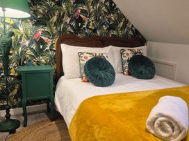 A bedroom with a bed and green accents at Frida's Cottage in Whitby