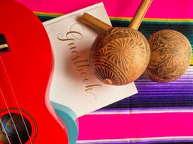 A ukulele and maracas on a decorative cloth at Frida's Cottage in Whitby