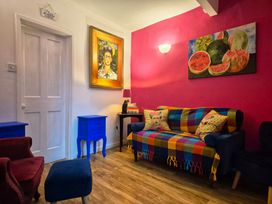 A living room with a colorful sofa art and side tables at Frida's Cottage in Whitby