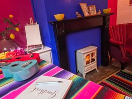 A living room with musical instruments and a small stove at Frida's Cottage in Whitby