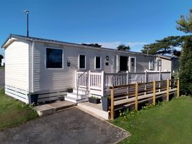 A mobile home with a porch and steps at 48 Woodland View in Lymington