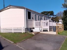 A mobile home with a deck and steps at 48 Woodland View in Lymington