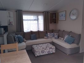 A living room with a sofa and coffee table at 48 Woodland View in Lymington