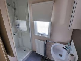 A bathroom with a shower and sink at 48 Woodland View in Lymington