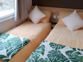 A bedroom with two beds and pillows at 48 Woodland View, Lymington