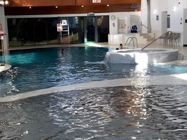 An indoor pool with a hot tub and pool steps at 48 Woodland View, Lymington