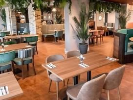 A dining room with tables and chairs at 48 Woodland View in Lymington