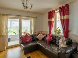 A living room with a sofa and sliding doors at Bank House Cottage in Lancaster
