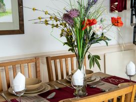 A dining table set with flowers and dinnerware at Bank House Cottage in Lancaster
