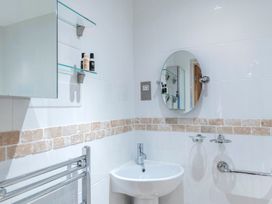 A bathroom with a sink and mirror at Bank House Cottage in Lancaster