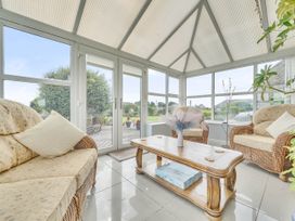 A conservatory with seating and a table at Bank House Cottage Glasson Dock