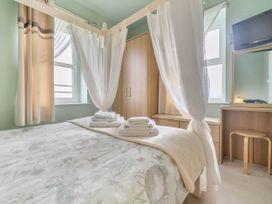 A bedroom with a bed and wardrobe at Bank House Cottage in Glasson Dock