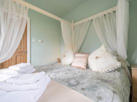 A bedroom with a bed and towels at Bank House Cottage in Glasson Dock