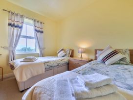 A bedroom with two single beds and a bedside table at Bank House Cottage in Glasson Dock