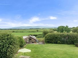 A garden with a shed and umbrella at Bank House Cottage Glasson Dock