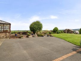 A garden with a conservatory and seating area at Bank House Cottage Glasson Dock