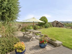 A garden with a table and umbrella at Bank House Cottage in Glasson Dock